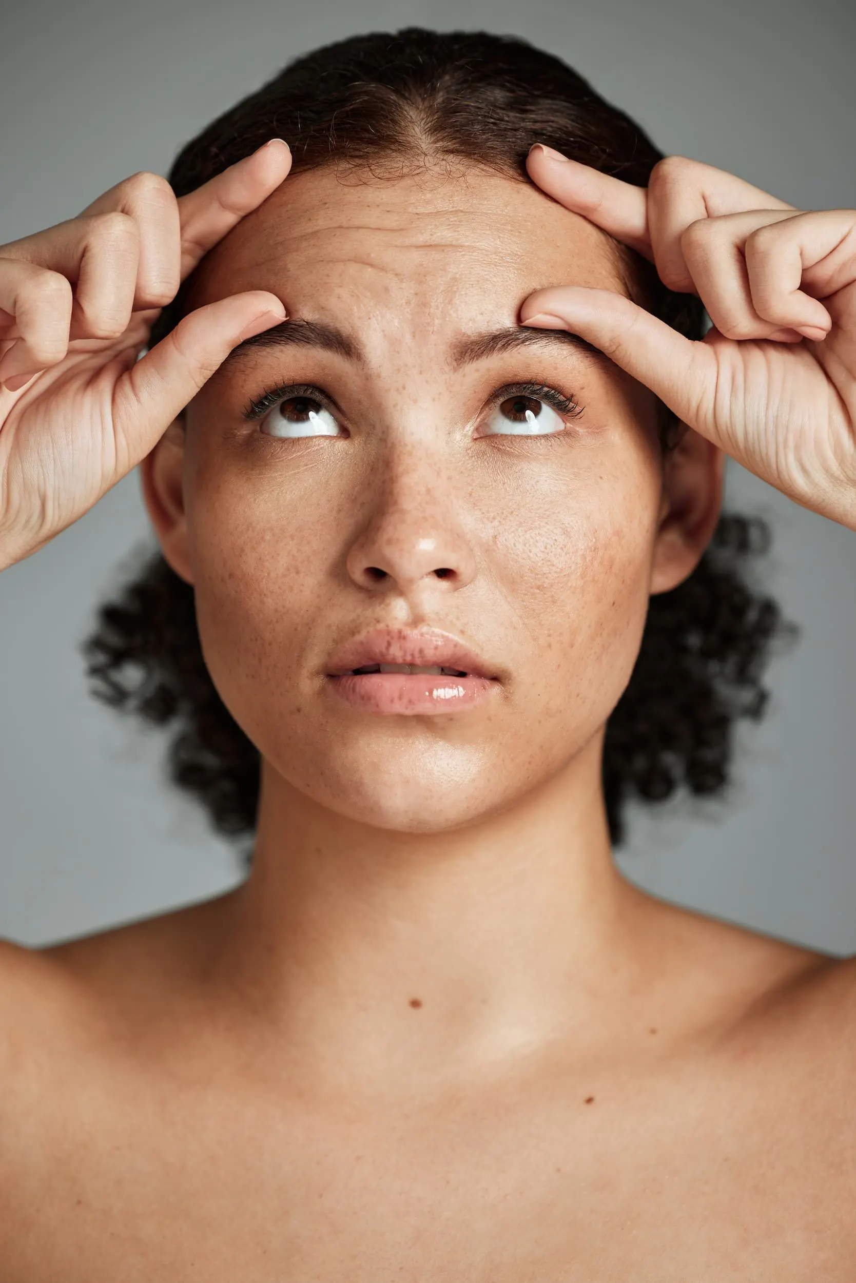 Person noticing fine lines in the mirror at Heritage Wellness & Med Spa Crescent Springs